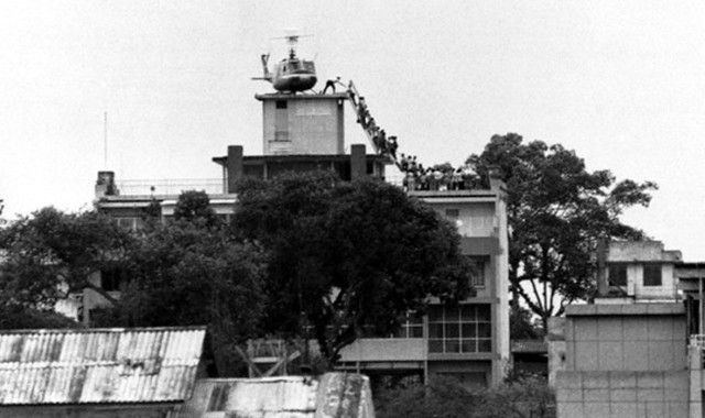 29 Apr 1975, Saigon, South Vietnam --- A CIA employee (probably O.B. Harnage) helps Vietnamese evacuees onto an Air America helicopter from the top of 22 Gia Long Street, a half mile from the U.S. Embassy. --- Image by © Bettmann/CORBIS