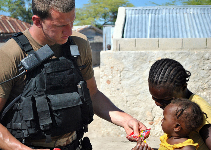 100127-N-9303D-002 ILE DE LA GONAVE, Haiti (Jan. 27, 2010) Firecontrolman 3rd Class Brad Morgan, assigned to the guided-missile cruiser USS Normandy (CG 60), gives candy to a young girl during an assessment and assistance visit to Ile De La Gonave, Haiti. Normandy is supporting Operation Unified Response following a 7.0 magnitude earthquake that caused severe damage in Haiti Jan. 12. (U.S. Navy Photo by Culinary Specialist 2nd Class George Disario/Released)