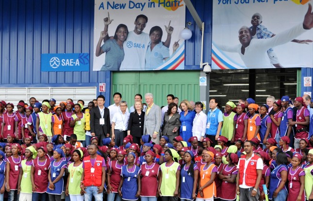 President Bill Clinton and Secretary of State Hillary Clinton pose for a photo with workers outside the Sae-A garment factory at Caracol Industrial Park ahead of the park’s inauguration on Oct. 22, 2012. Photo by Kendra Helmer/USAID