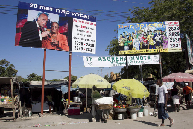 A man walks past billboards calling on people to participate in elections in Port au Prince on March 20, 2011. Haitians headed to the polls for the final round of elections. Photo Victoria Hazou UN/MINUSTAH
